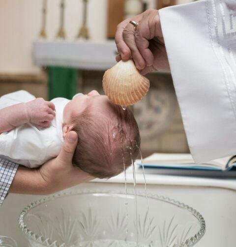 Photo d’un enfant en train de se faire baptiser à l’église